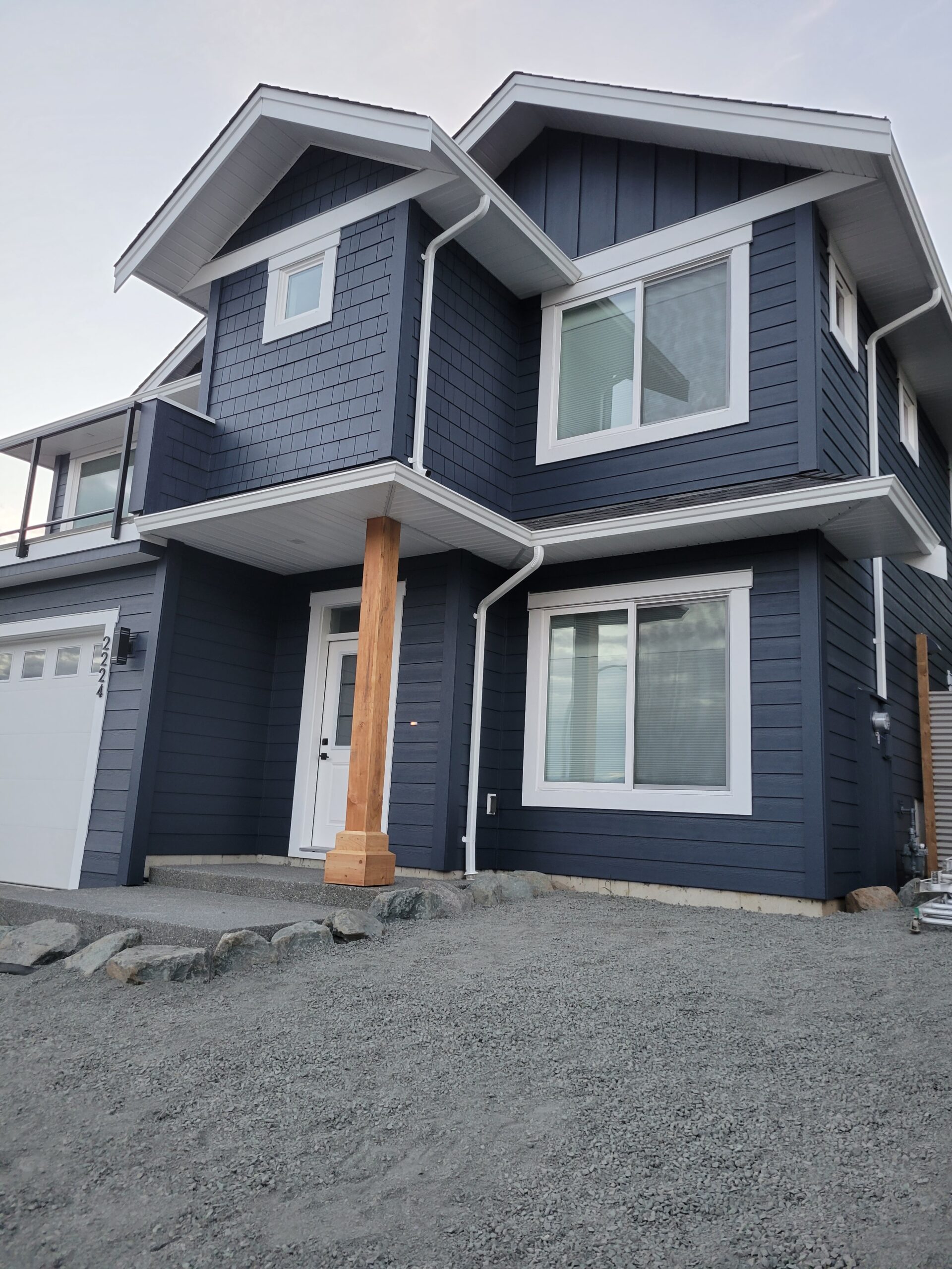 Exterior house painting with dark siding and white trim