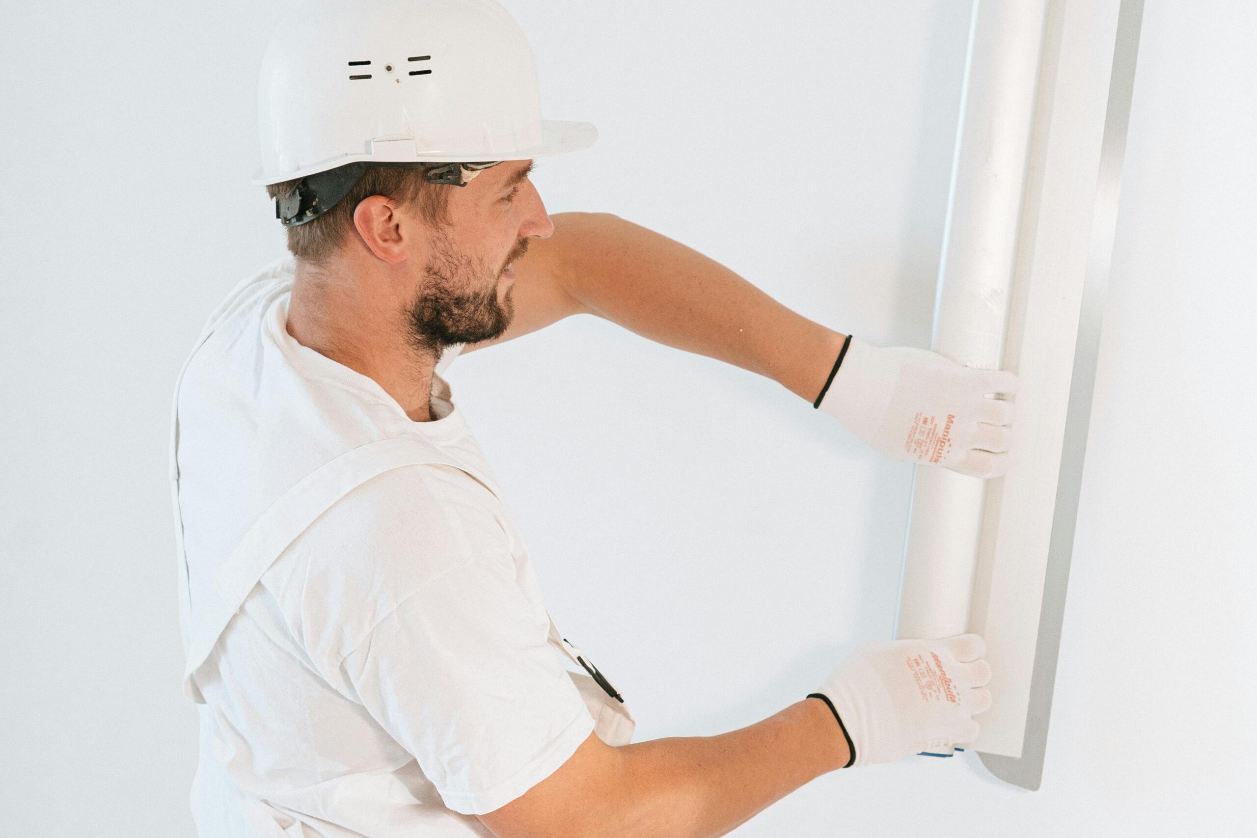 Tradesperson repairing drywall before painting a room