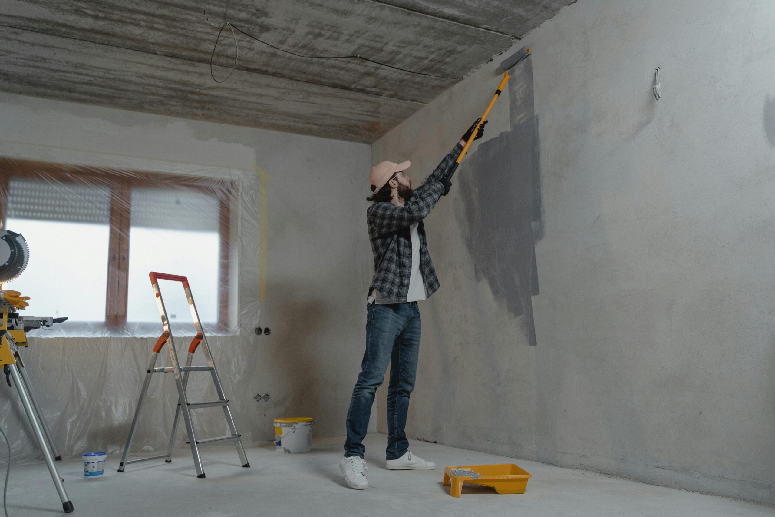 Painter rolling fresh paint onto an interior wall in a Calgary home